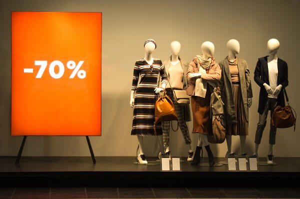 Um bom gatilho pode gerar muitas vendas Vitrine de loja com manequins e uma placa com 70% de desconto
