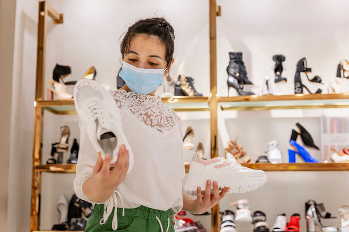 mulher usando máscara enquanto faz compras