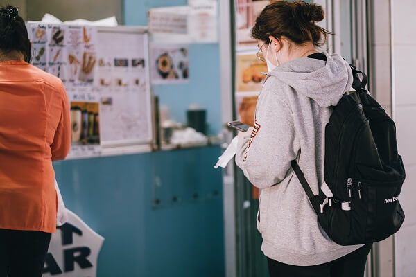 Seguir as normas de distanciamento social ajuda no combate à pandemia Mulher com máscara mantendo o distanciamento de outra mulher