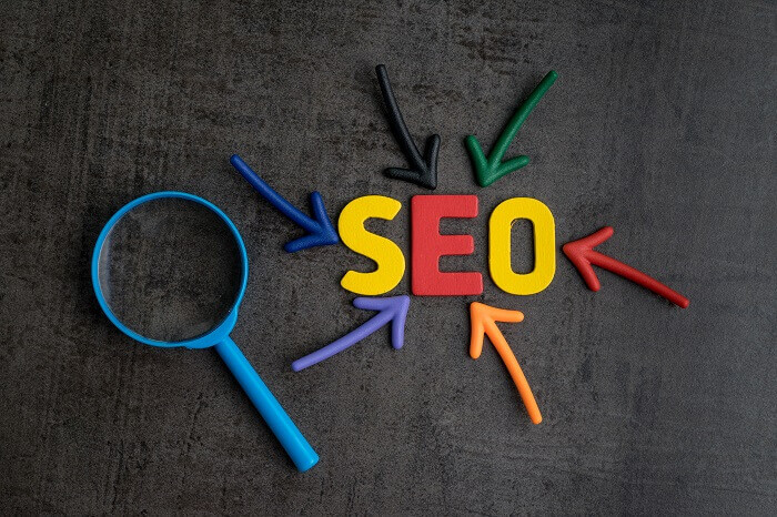 Palavra "SEO" com setas e lupa ao redor
