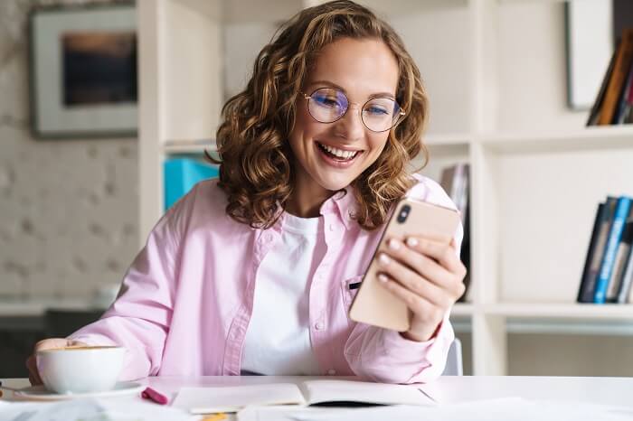 Mulher mexendo em smartphone e rindo