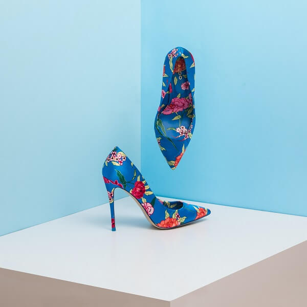 Sapato de salto alto azul com rosas em uma vitrine