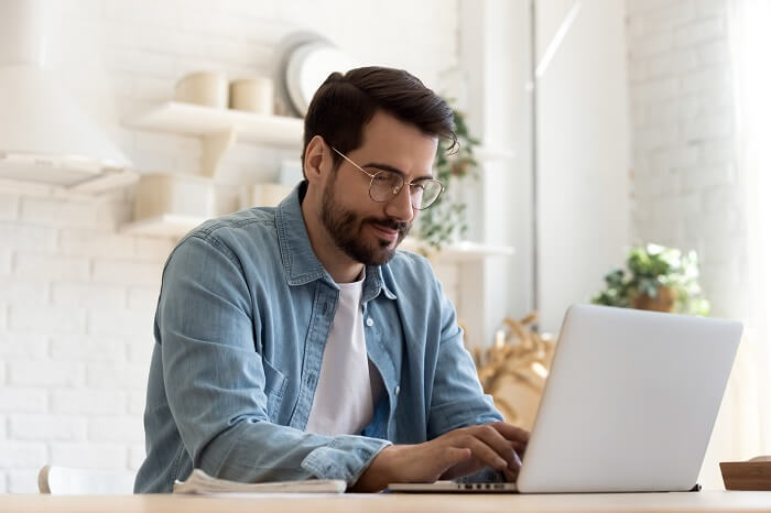 Homem branco fazendo pesquisas em notebook