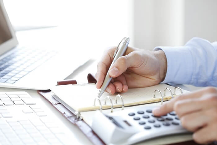 Mãos masculinas fazendo conta em calculadora